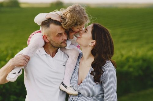 A delightful family moment captured in a lush scenic field, portraying love and happiness.